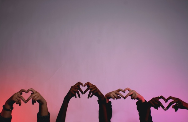 Hands in air in shape of hearts